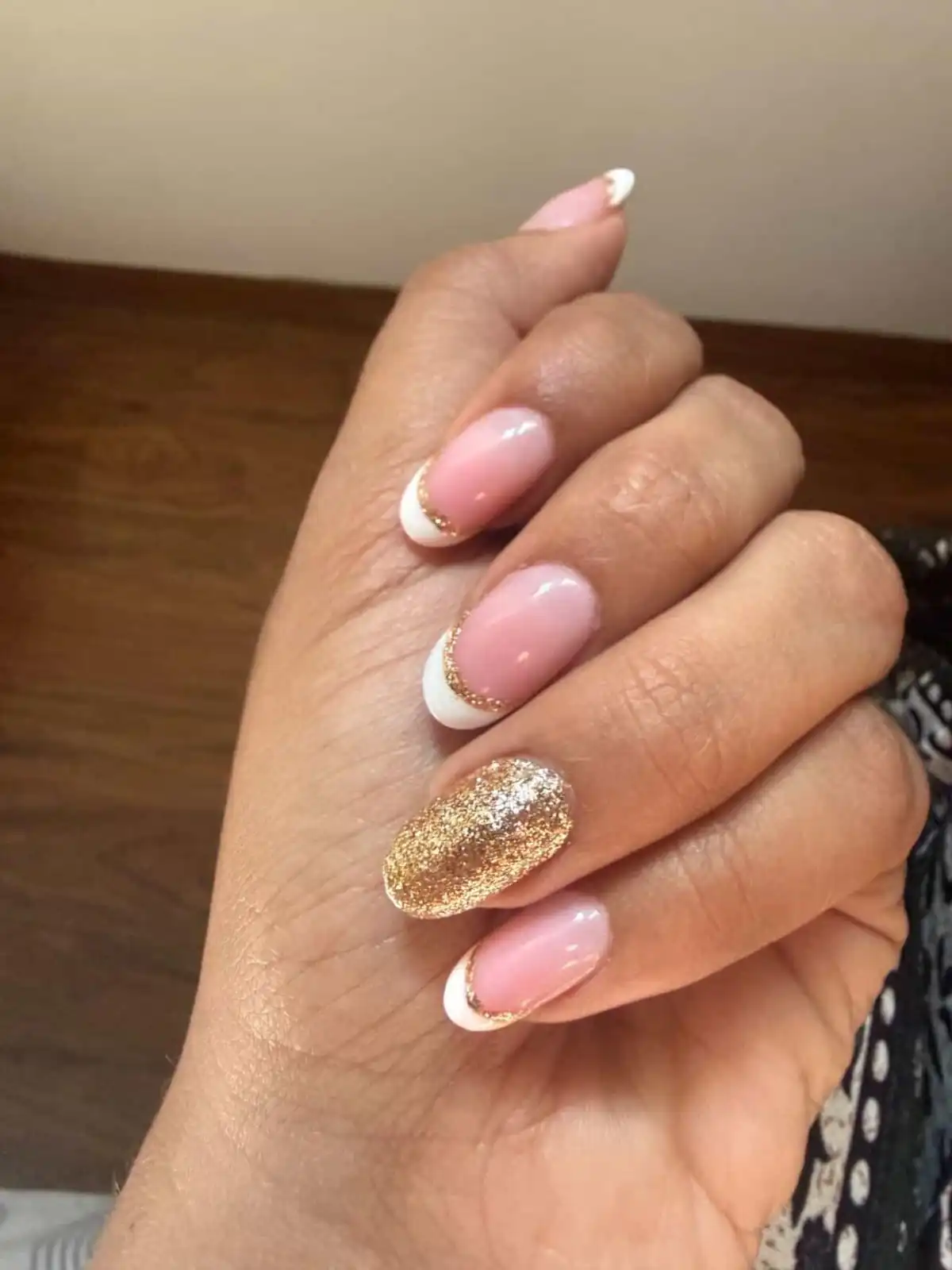 Pink French tip nails with gold glitter accent manicure in Thrissur.