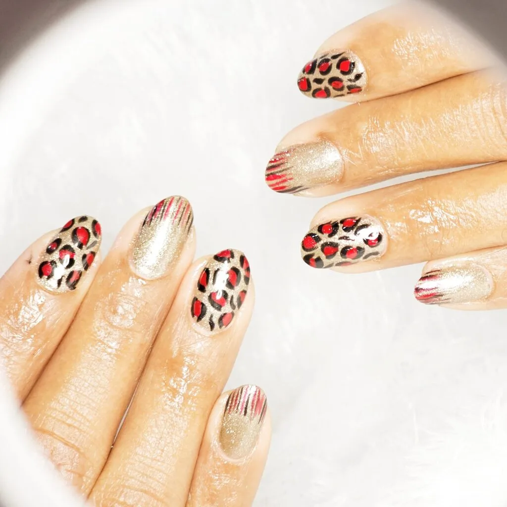 Elegant glitter nail art with leopard accents in Thrissur.