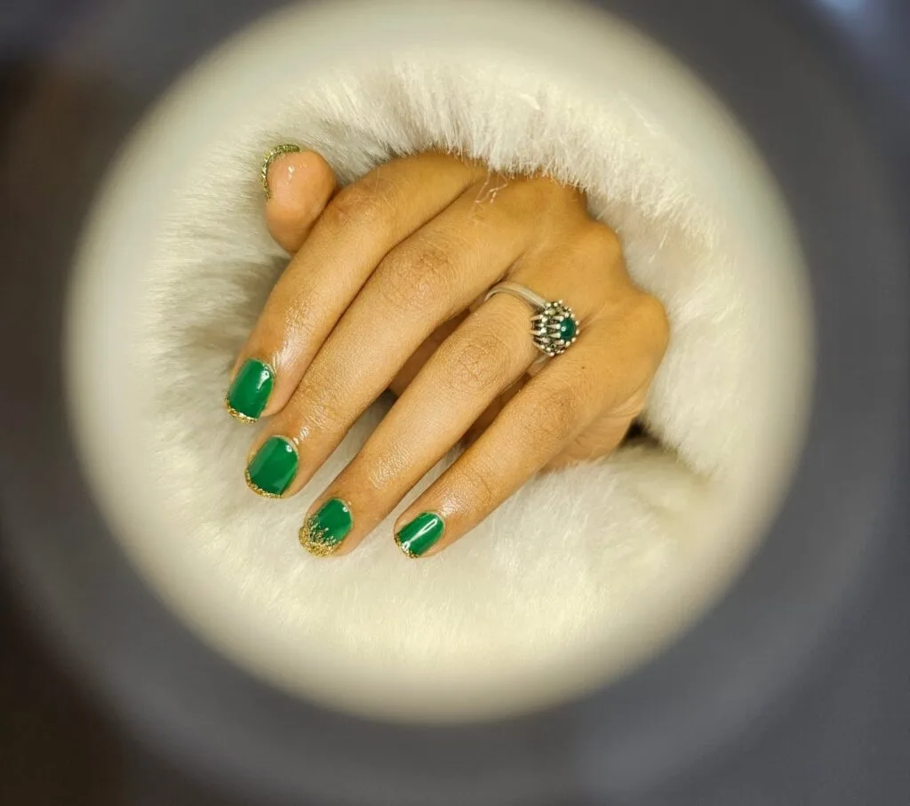 Elegant green manicure with glitter French tip nail design in Thrissur.