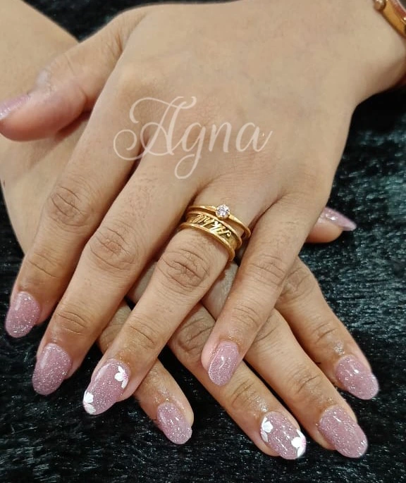 Pink shimmer butterfly nail art by a luxury nail studio in Thrissur