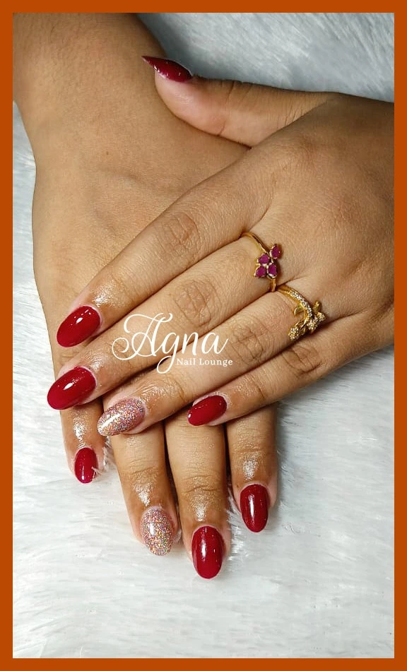 Premium nail art in Thrissur with elegant red glossy nail extensions.