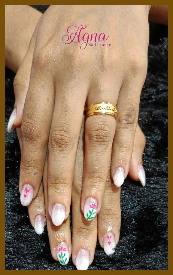 White glitter nails with floral nail art design in Thrissur.